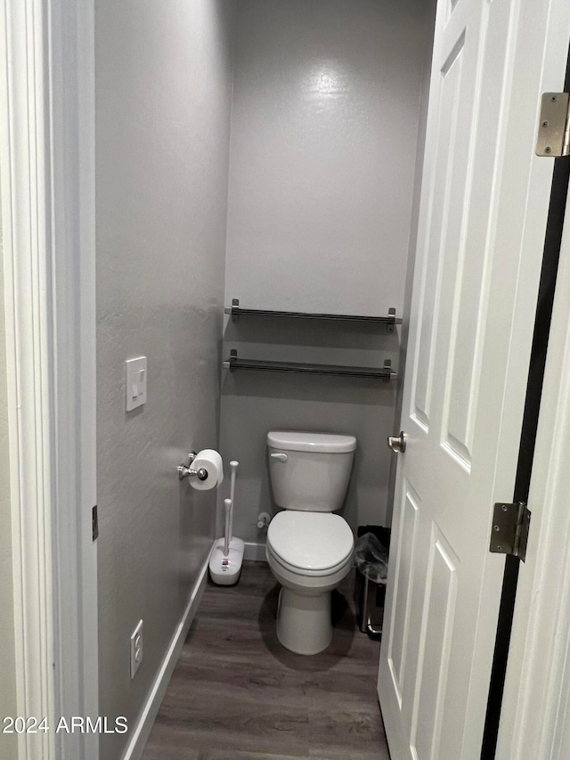 bathroom featuring toilet and wood-type flooring