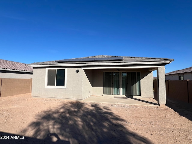 rear view of house featuring a patio and solar panels