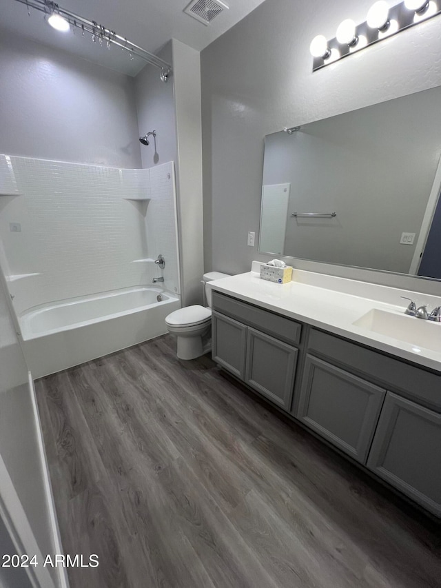 full bathroom with toilet, hardwood / wood-style floors, vanity, and  shower combination