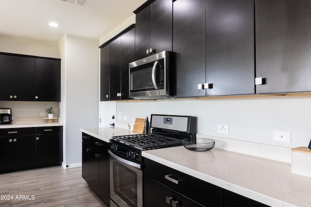 kitchen featuring stainless steel appliances and light hardwood / wood-style flooring