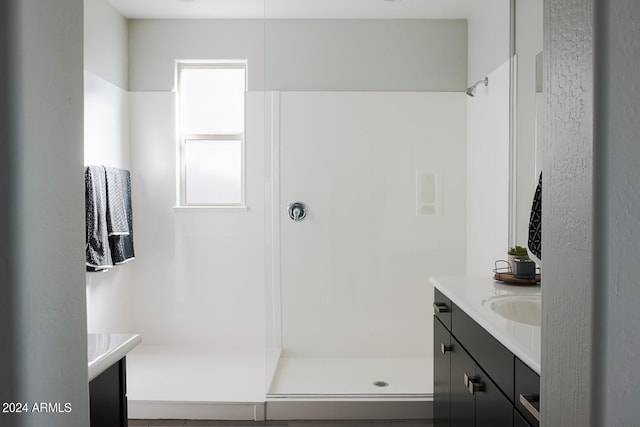 bathroom featuring a shower and vanity