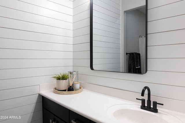 bathroom featuring vanity and wooden walls