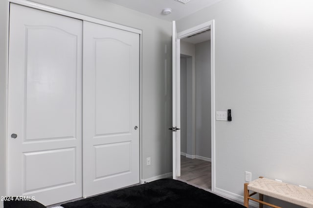 unfurnished bedroom featuring hardwood / wood-style floors and a closet