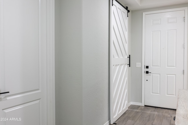 entryway with a barn door and light hardwood / wood-style floors