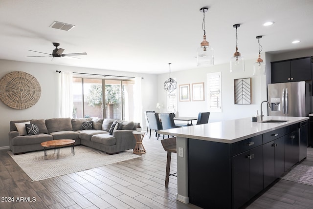 kitchen featuring pendant lighting, sink, dark hardwood / wood-style floors, and an island with sink