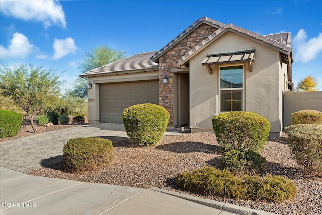 29007 N 120th Dr, Peoria, AZ 85383 - view of front of home featuring an attached garage, a tiled roof, stucco siding, stone siding, and driveway