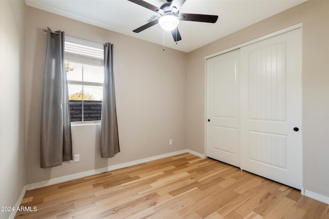 unfurnished bedroom with ceiling fan, light wood-type flooring, and a closet