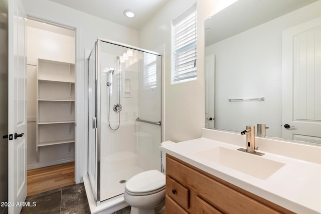 bathroom featuring vanity, hardwood / wood-style flooring, toilet, and an enclosed shower