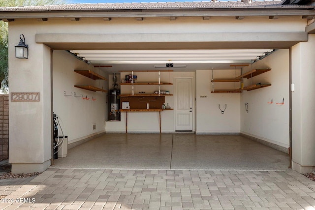 garage featuring strapped water heater and a carport