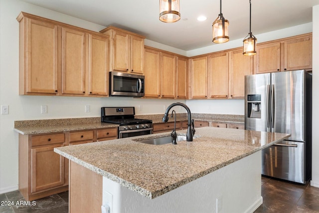 kitchen featuring light stone countertops, appliances with stainless steel finishes, a kitchen island with sink, sink, and decorative light fixtures