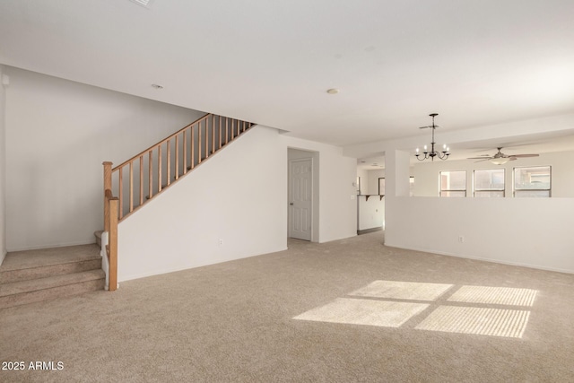 unfurnished living room with stairs, ceiling fan with notable chandelier, and carpet flooring
