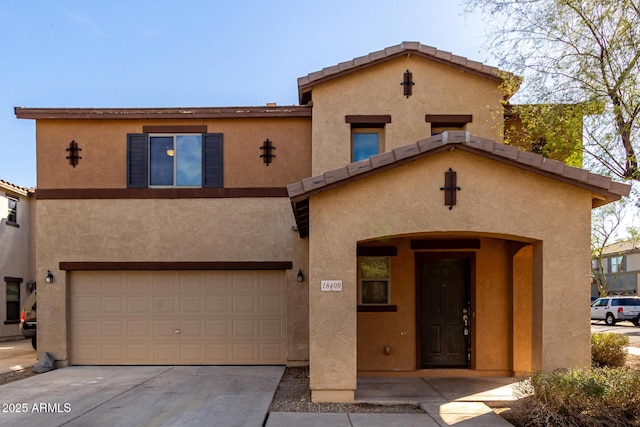 view of front of home featuring a garage, concrete driveway, a tile roof, and stucco siding