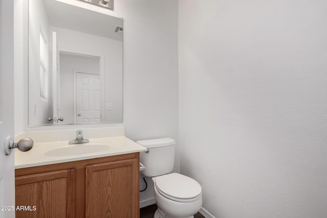 half bath with toilet, visible vents, and vanity