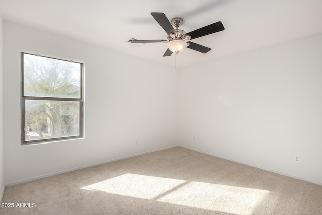 carpeted spare room with baseboards and a ceiling fan
