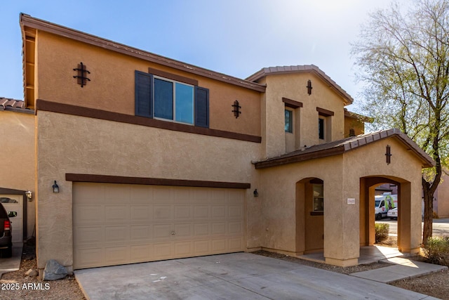 view of front of property featuring an attached garage, a tiled roof, concrete driveway, and stucco siding