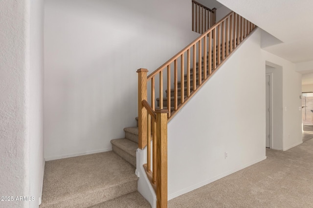 stairway featuring carpet flooring and baseboards