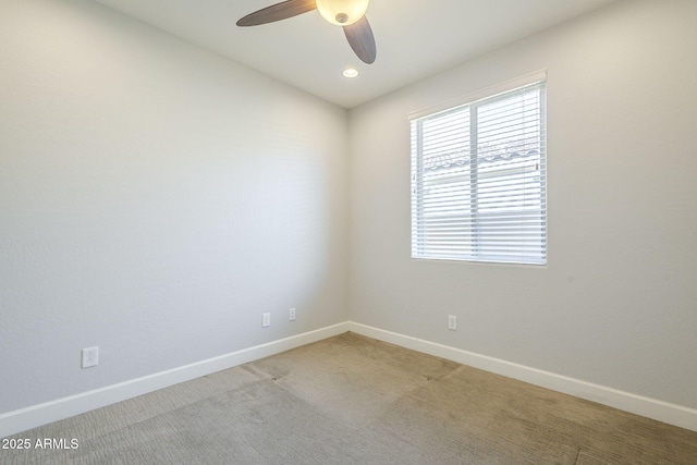 unfurnished room with a ceiling fan, baseboards, and carpet