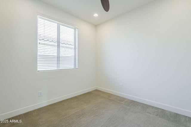 unfurnished room with light colored carpet, baseboards, and a ceiling fan