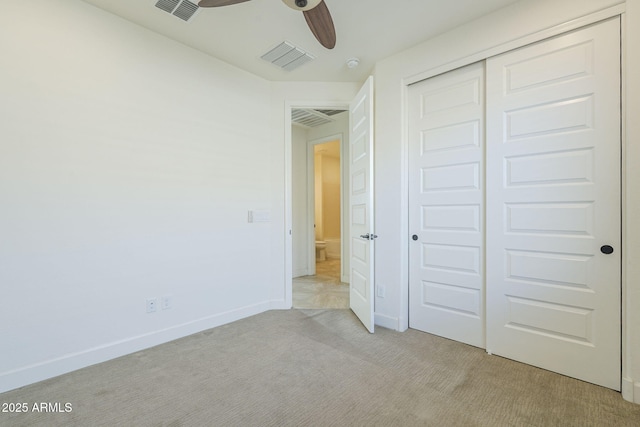 unfurnished bedroom featuring light colored carpet, a closet, baseboards, and ceiling fan