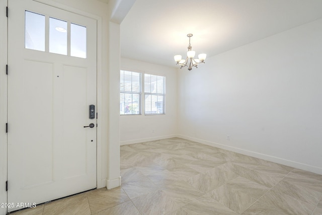 entrance foyer featuring a chandelier and baseboards