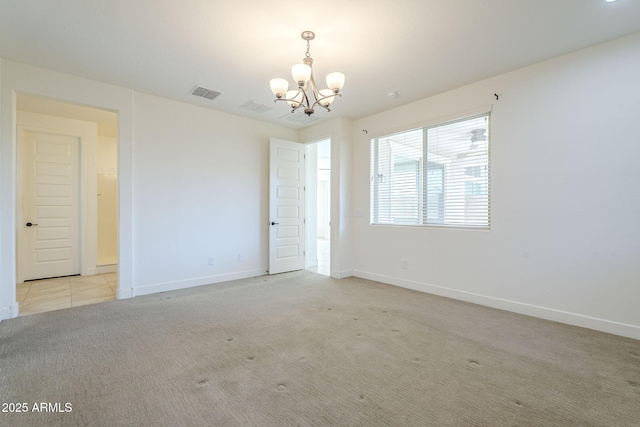 spare room with a chandelier, light colored carpet, and baseboards