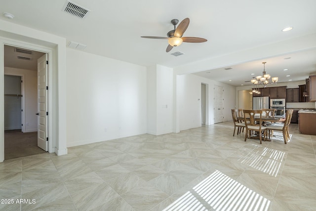 living room with ceiling fan, a chandelier, and baseboards