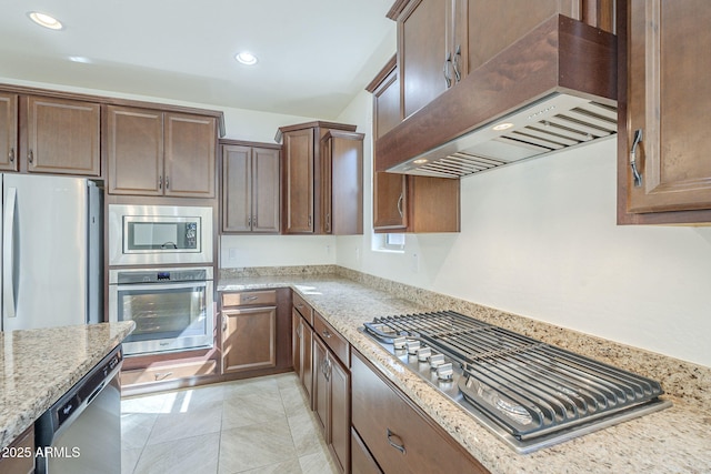 kitchen with stainless steel appliances, custom exhaust hood, light stone counters, and recessed lighting