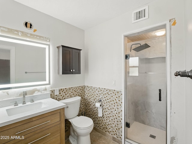 12210 N 67th St, Scottsdale, AZ 85254 - bathroom featuring vanity, a shower stall, a wainscoted wall, tile walls, and tile patterned floors