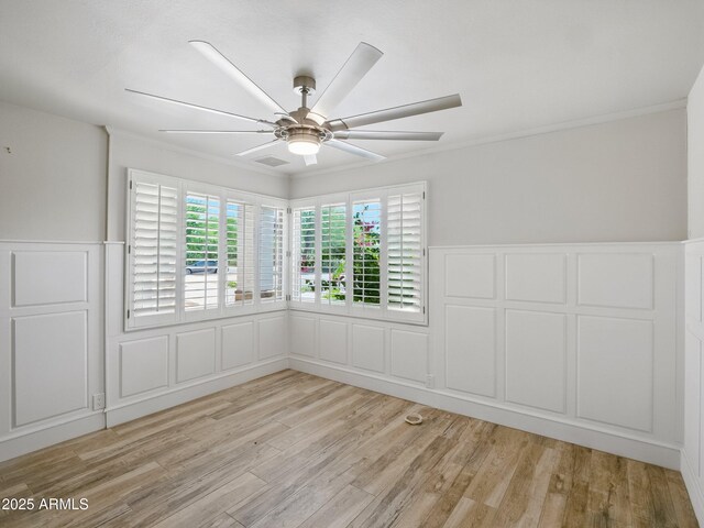 12210 N 67th St, Scottsdale, AZ 85254 - spare room featuring a decorative wall, light wood-style flooring, wainscoting, crown molding, and ceiling fan