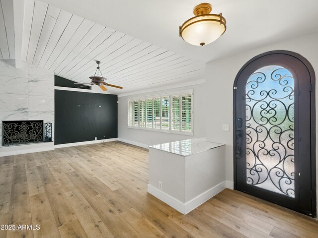 12210 N 67th St, Scottsdale, AZ 85254 - foyer entrance featuring arched walkways, light wood-style flooring, ceiling fan, wooden ceiling, and a fireplace