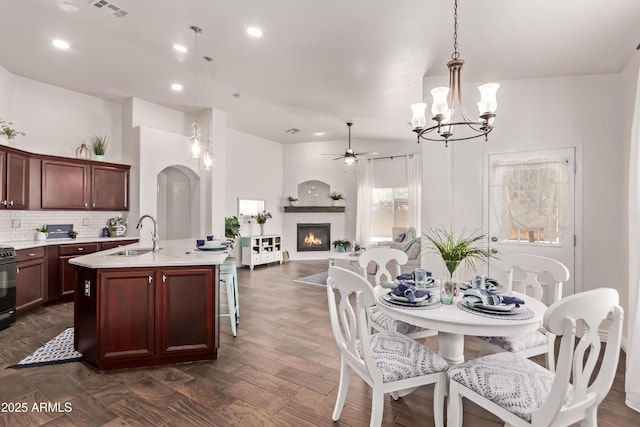 14864 W Riviera Dr, Surprise, AZ 85379 - kitchen featuring ceiling fan, a chandelier, a kitchen island with sink, decorative light fixtures, and decorative backsplash