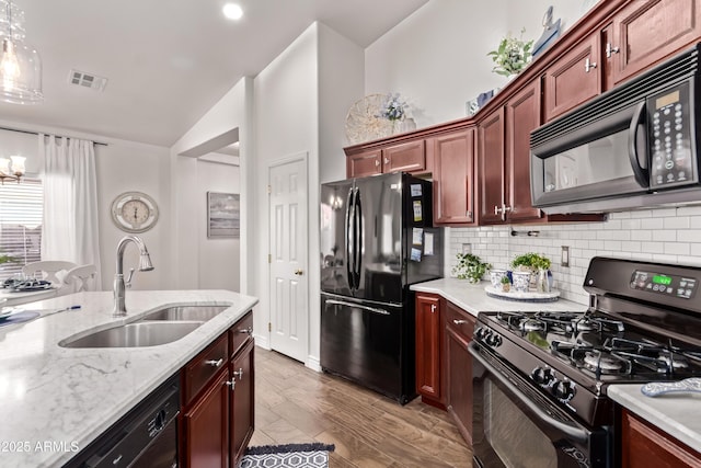 14864 W Riviera Dr, Surprise, AZ 85379 - kitchen with black appliances, lofted ceiling, tasteful backsplash, light stone countertops, and a chandelier