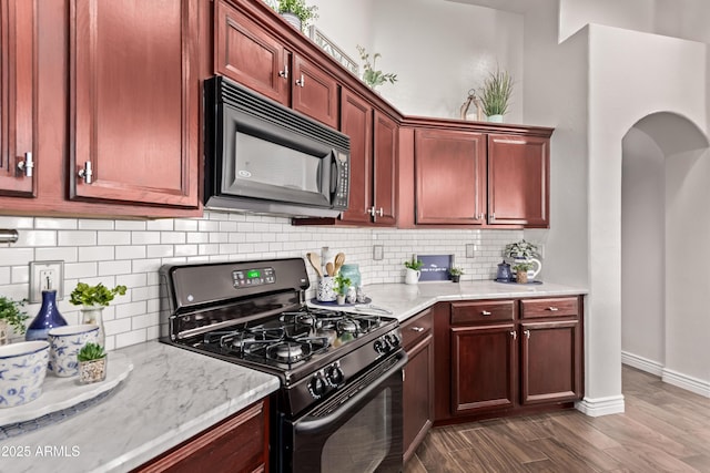 14864 W Riviera Dr, Surprise, AZ 85379 - kitchen with black appliances, dark wood-style flooring, reddish brown cabinets, and decorative backsplash