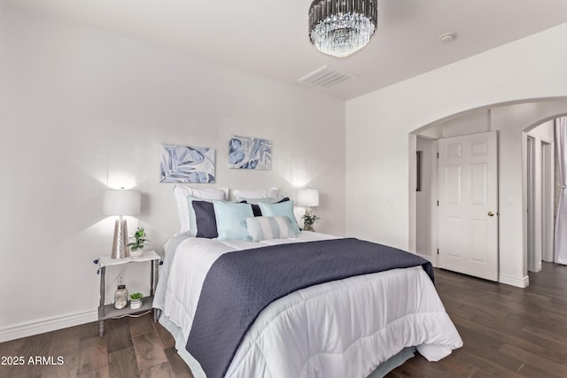 14864 W Riviera Dr, Surprise, AZ 85379 - bedroom with arched walkways, dark wood-type flooring, and a chandelier