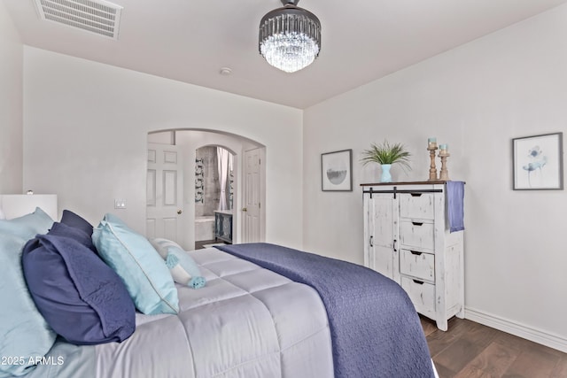 14864 W Riviera Dr, Surprise, AZ 85379 - bedroom with arched walkways, dark wood-type flooring, a chandelier, and ensuite bathroom