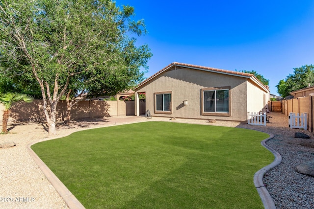 14864 W Riviera Dr, Surprise, AZ 85379 - rear view of house featuring stucco siding, a fenced backyard, a tile roof, and a patio