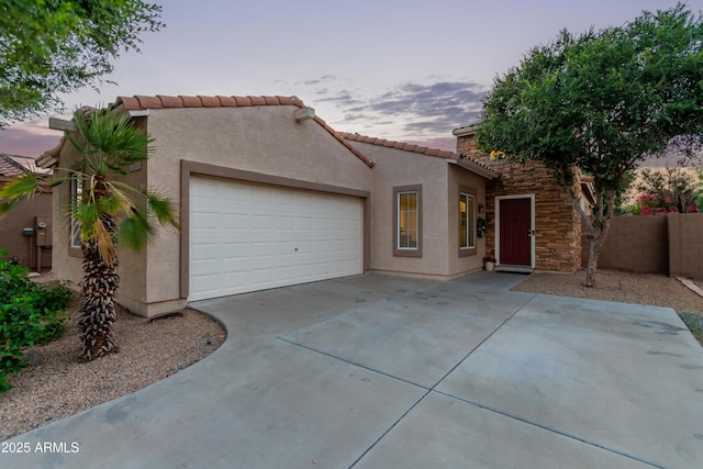 14864 W Riviera Dr, Surprise, AZ 85379 - mediterranean / spanish home featuring stucco siding, an attached garage, driveway, a tile roof, and stone siding