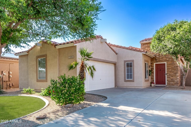 14864 W Riviera Dr, Surprise, AZ 85379 - mediterranean / spanish house featuring concrete driveway, an attached garage, stucco siding, and a tile roof