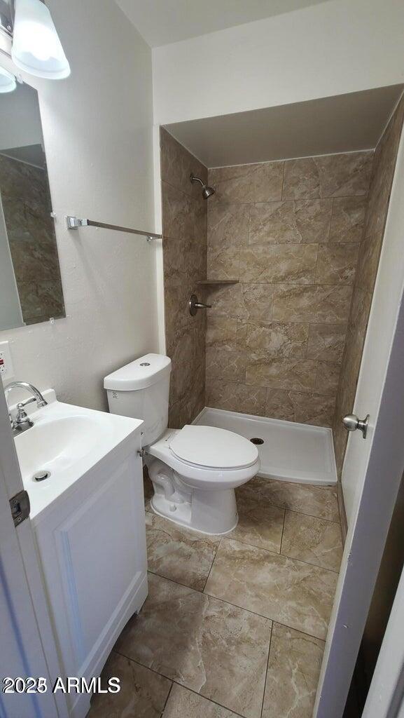 2908 N 53rd Ln, Phoenix, AZ 85031 - full bathroom with vanity, a shower stall, and toilet