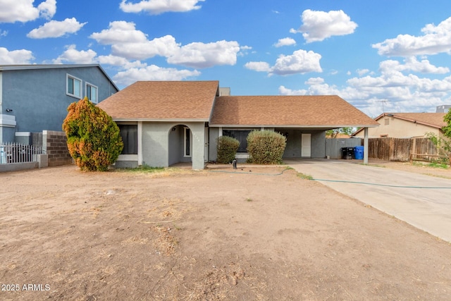 9028 W Osborn Rd, Phoenix, AZ 85037 - ranch-style house featuring concrete driveway, a shingled roof, fence, an attached carport, and stucco siding