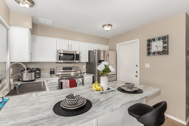 9028 W Osborn Rd, Phoenix, AZ 85037 - kitchen with stainless steel appliances, a peninsula, a sink, and white cabinetry