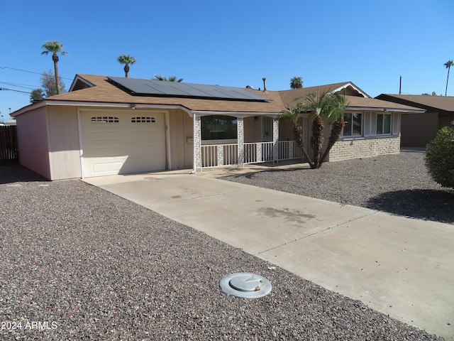 single story home featuring a garage and solar panels