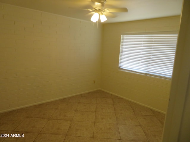 tiled spare room featuring ceiling fan