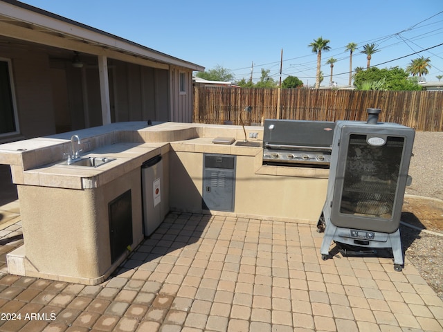 view of patio featuring area for grilling, sink, and a grill