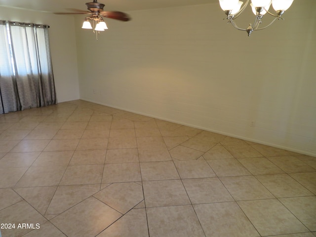 unfurnished room with ceiling fan with notable chandelier and light tile patterned floors