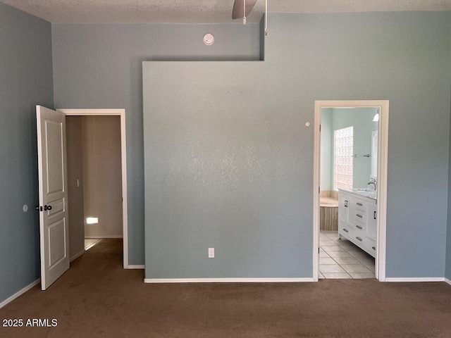 3876 Camino Del Vara, Sierra Vista, AZ 85650 - unfurnished bedroom with carpet, baseboards, connected bathroom, and a textured ceiling