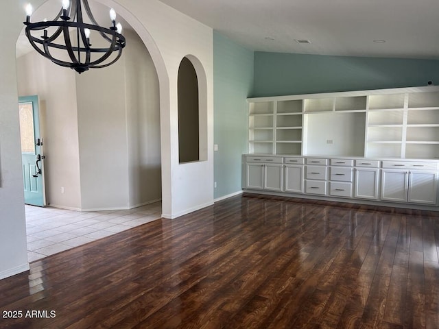 3876 Camino Del Vara, Sierra Vista, AZ 85650 - unfurnished room featuring wood finished floors, arched walkways, a chandelier, high vaulted ceiling, and baseboards