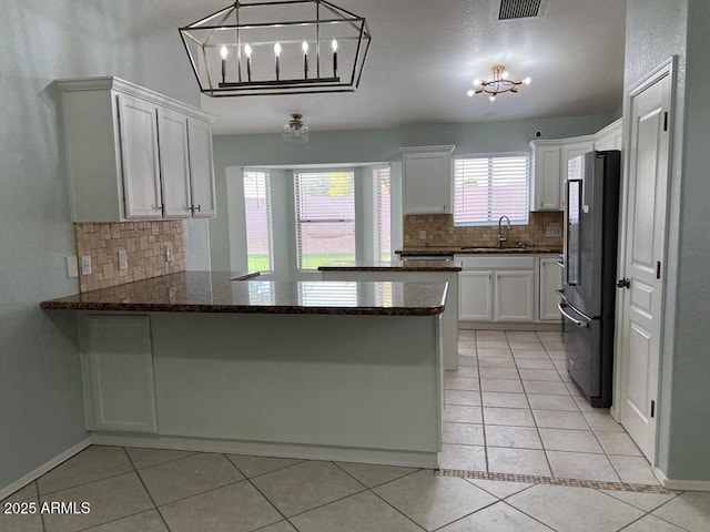 3876 Camino Del Vara, Sierra Vista, AZ 85650 - kitchen with freestanding refrigerator, a chandelier, a sink, a peninsula, and backsplash
