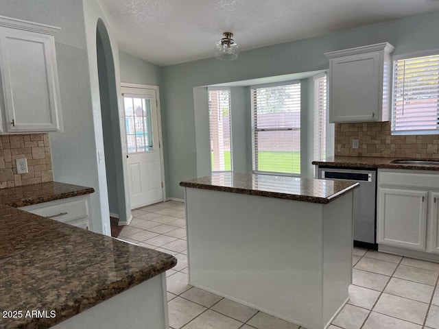 3876 Camino Del Vara, Sierra Vista, AZ 85650 - kitchen featuring stainless steel dishwasher, light tile patterned floors, backsplash, lofted ceiling, and white cabinets