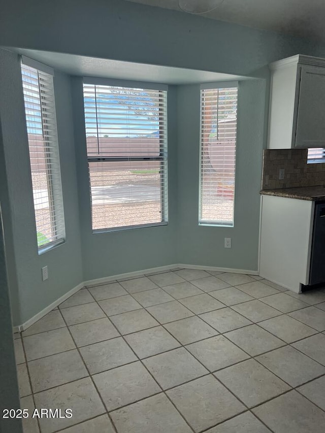 3876 Camino Del Vara, Sierra Vista, AZ 85650 - unfurnished dining area with light tile patterned floors, plenty of natural light, and baseboards